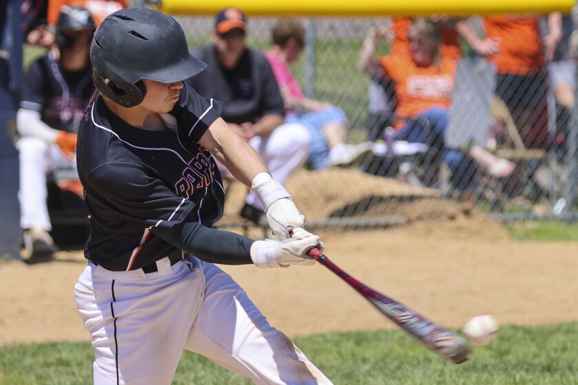 High school boys in black and orange uniforms with white pants play baseball