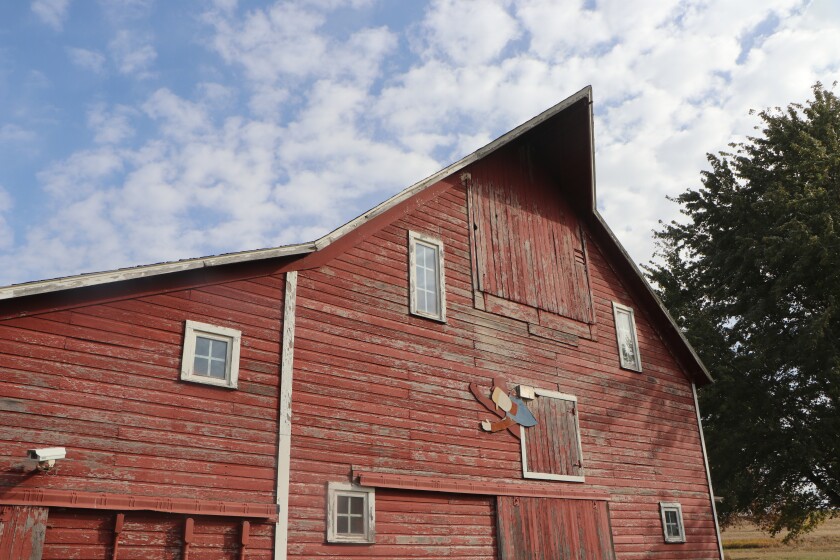 A classic barn has a fading, wooden "Zeke" the toy farm "freak" logo on it. The barn was a museum from 1995 to about 2018.