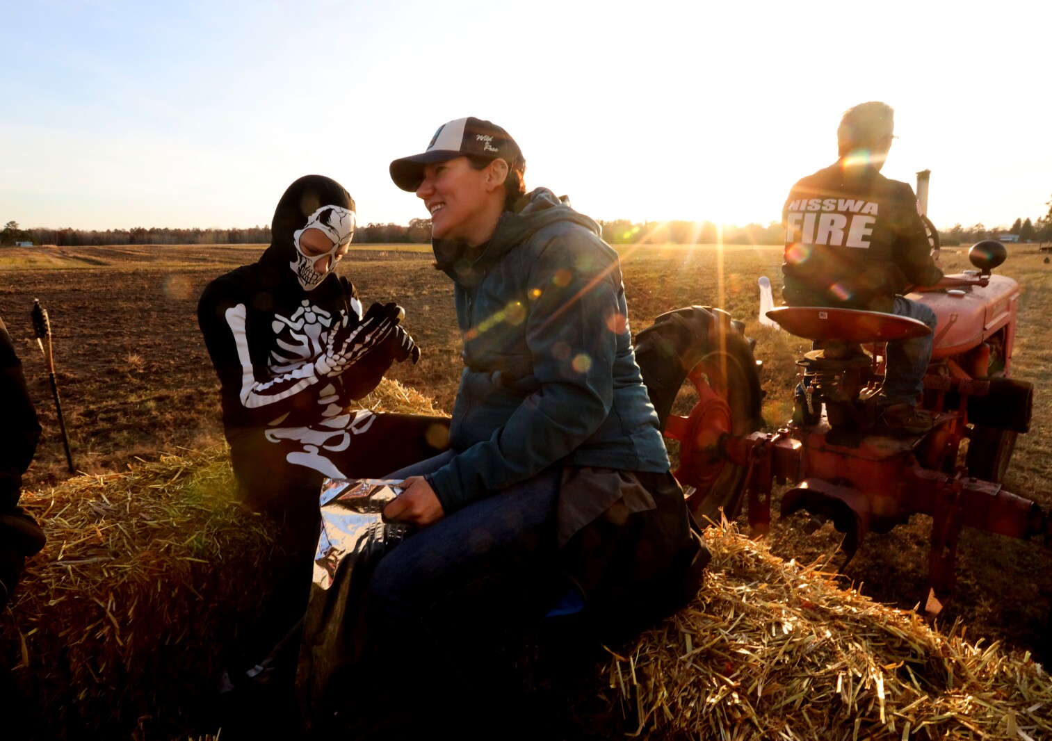 People take a hayride around the farm as the sunset.