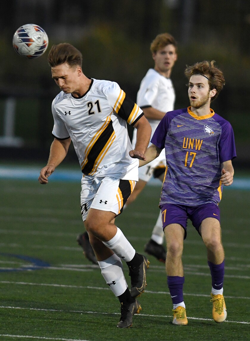 UW-Superior’s Noah Benson (21) heads the ball up field in front of Northwestern’s Aaron Hill (17)