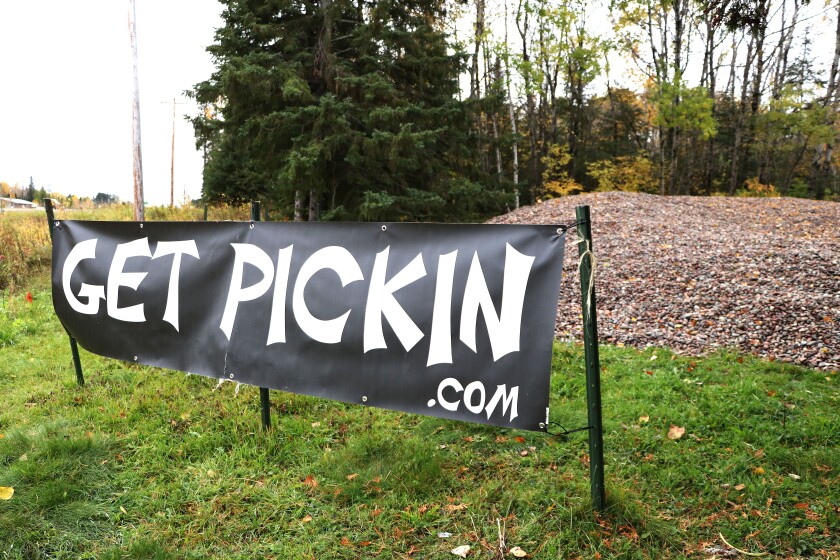A sign stands in front of a pile of rocks.