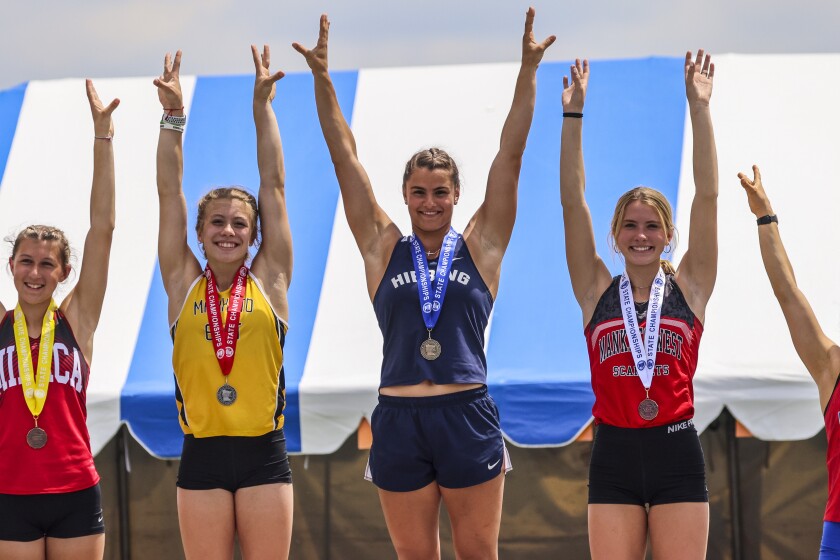 High school athletes compete in track and field events at outdoor stadium