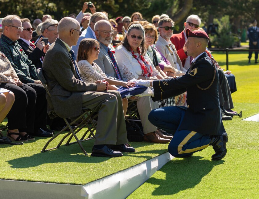 The flag that draped the casket of U.S. Army Air Forces 2nd Lt. William J. McGowan is presented to his family at his burial Saturday with full military honors at the Normandy American Cemetery in France. The plane McGowan, of Benson, was piloting was shot down on D-day, June 6, 1944, over France. His remains were recovered in 2018 and identified in 2019.