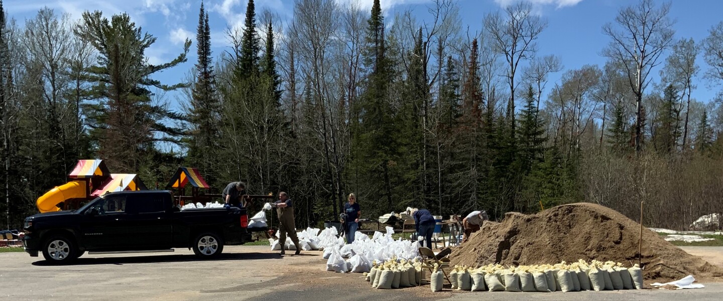People loading sandbags in back of truck