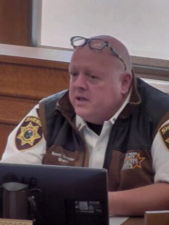 Sheriff Scott Goddard speaks at a desk