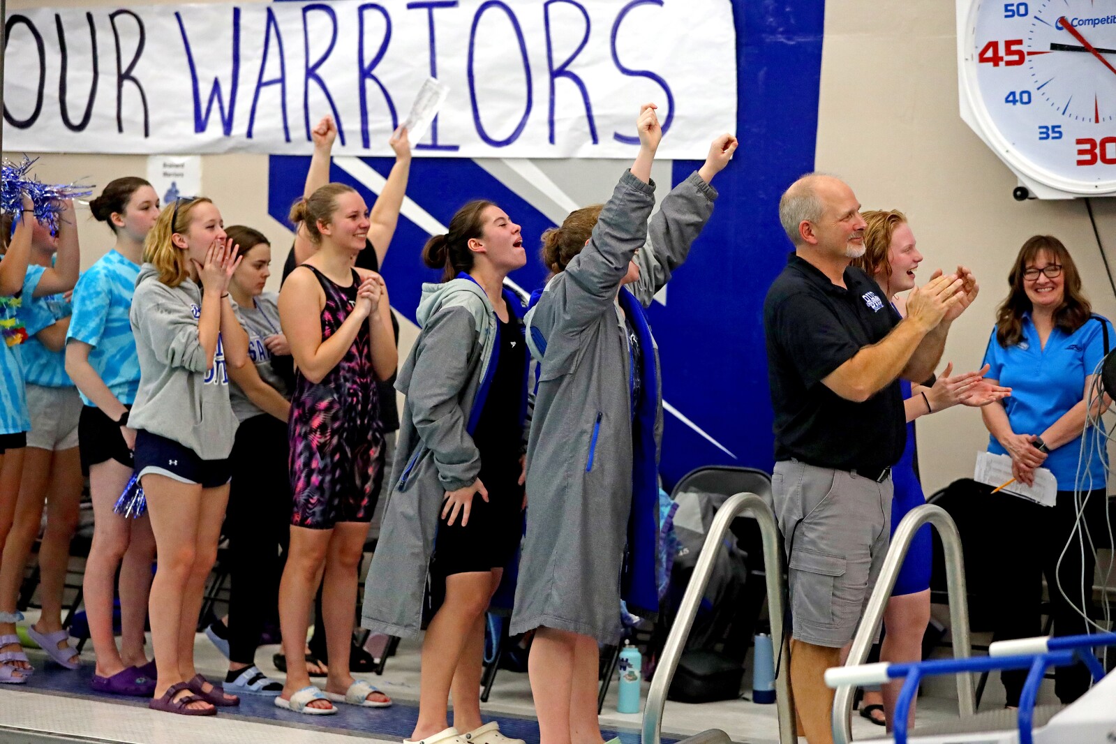 Brainerd swimmers and coaches cheer as Mya Tautges receives her silver medal.