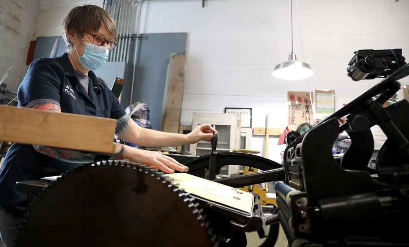Janelle Miller runs an over-100-year-old printing press