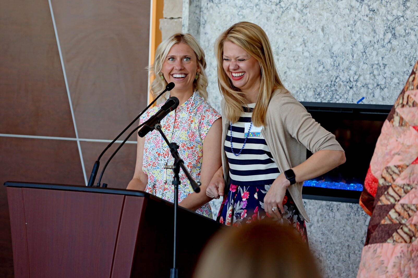Two women speak at a microphone