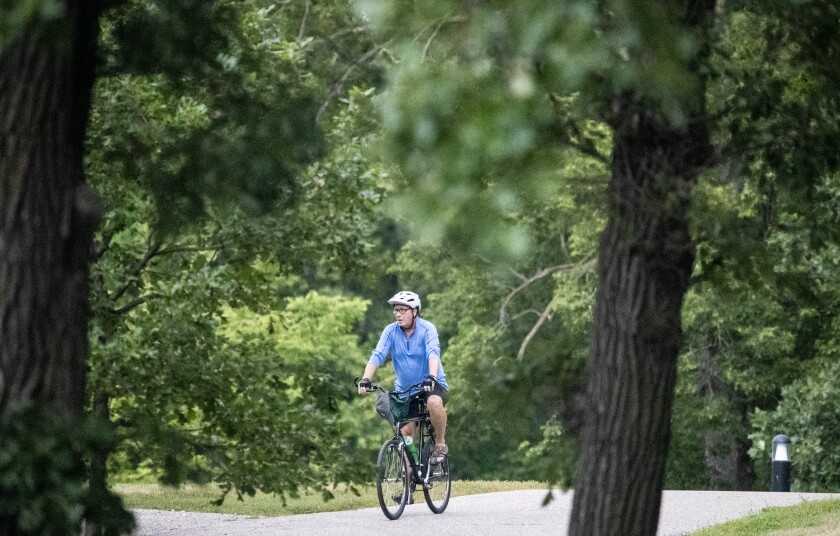A cyclist pedals through Robbins Island Regional Park during Rockin' Robbins in Willmar on Tuesday, July 26, 2022.