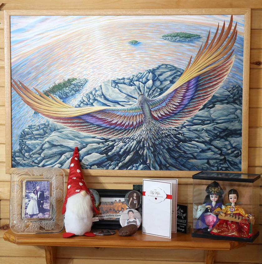 Bird painting hangs over shelf.