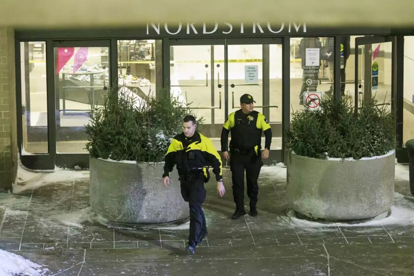 00fb38-20221223-two-police-officers-walking-out-of-a-store-webp1400.jpg
