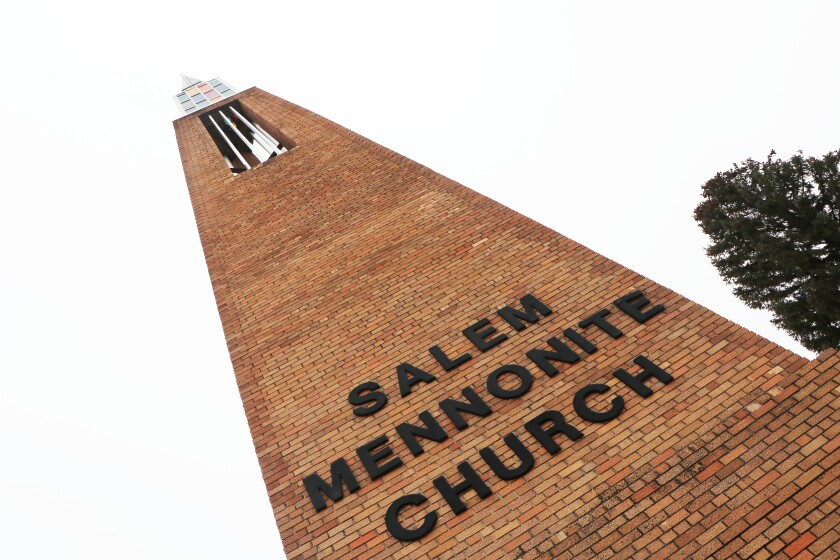 A tall brick steeple and cross stand in front of the Salem Mennonite Church, south of Freeman, S.D.
