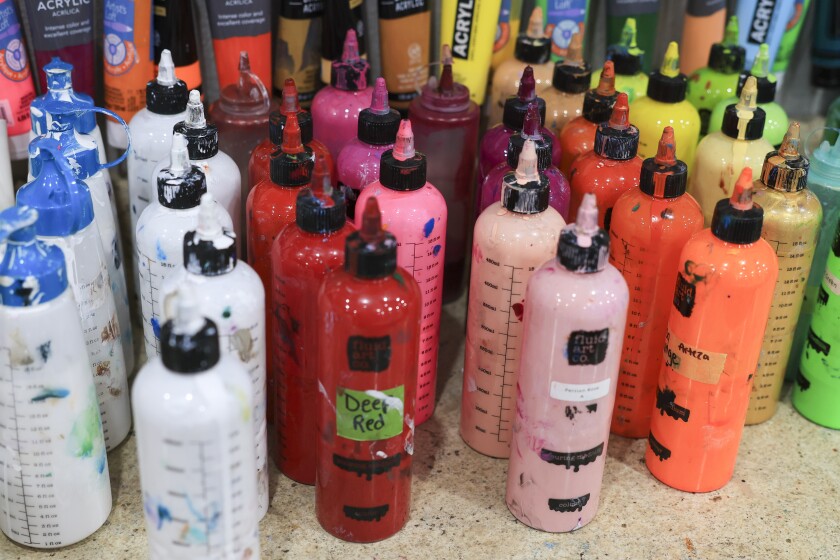 woman create fuid art work using paint