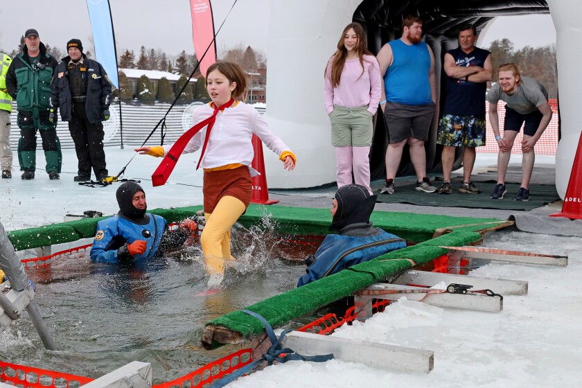People jump into the water during the Polar Plunge event on Pelican Lake.