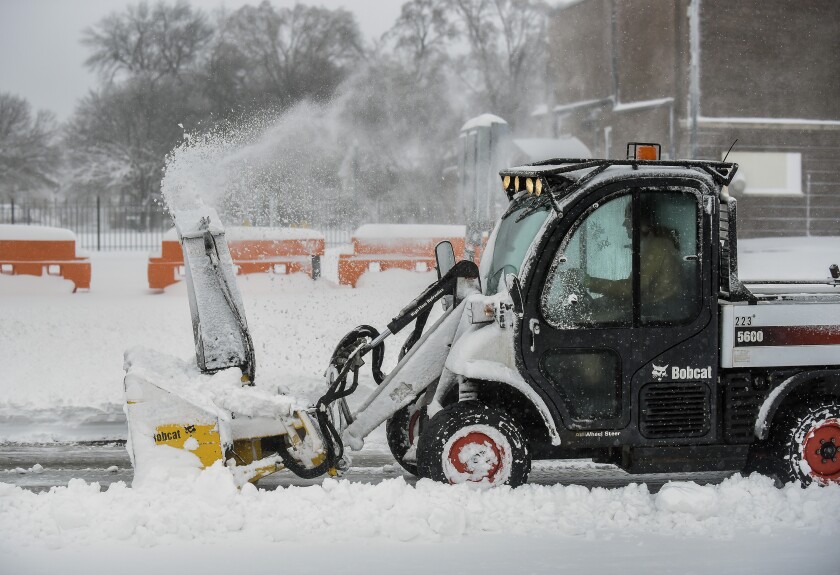Alex Young, with the Mitchell Parks, Recreation and Forestry department, clears the sidewalk in the 400 block of North Main Street on Thursday in Mitchell. (Matt Gade / Republic)
