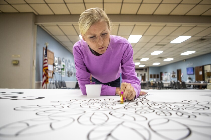 Willmar Community Center manager Britta Diem paints leaf petals on a tree while taking part in painting on the Willmar Little Art Gallery mural on Tuesday, July 26, 2022.