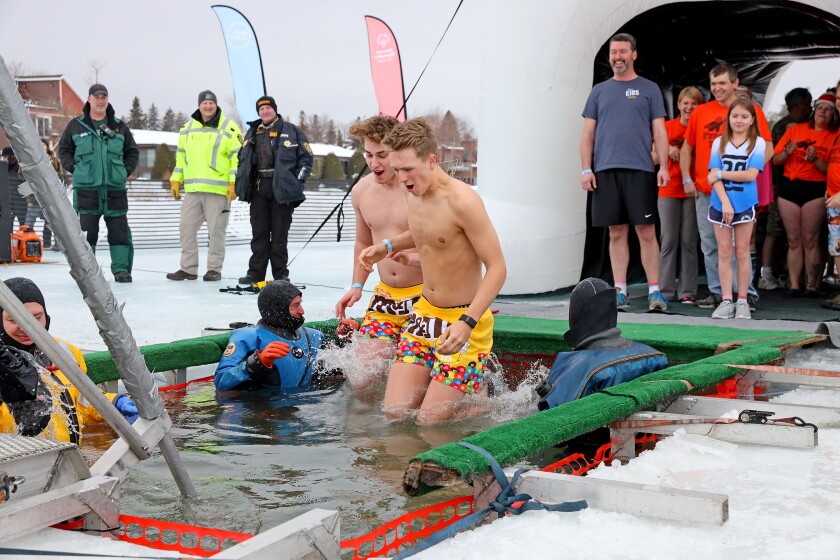 People jump into the water during the Polar Plunge event on Pelican Lake.