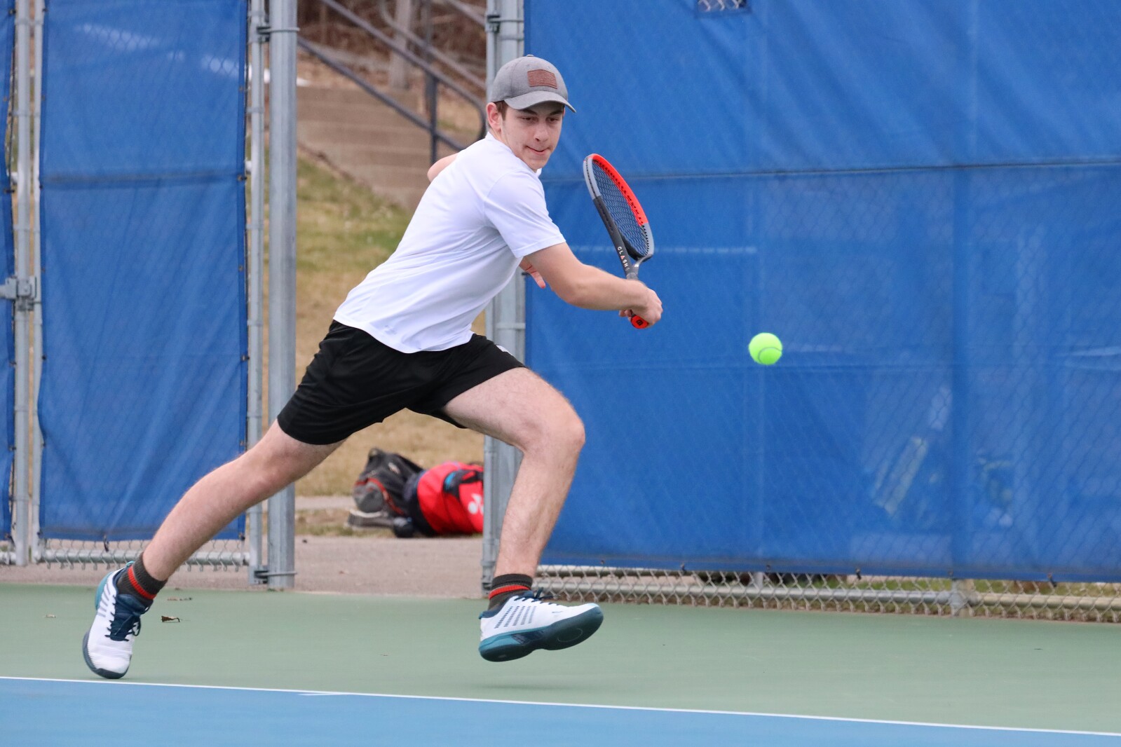 Tennis player hits the ball on the court.