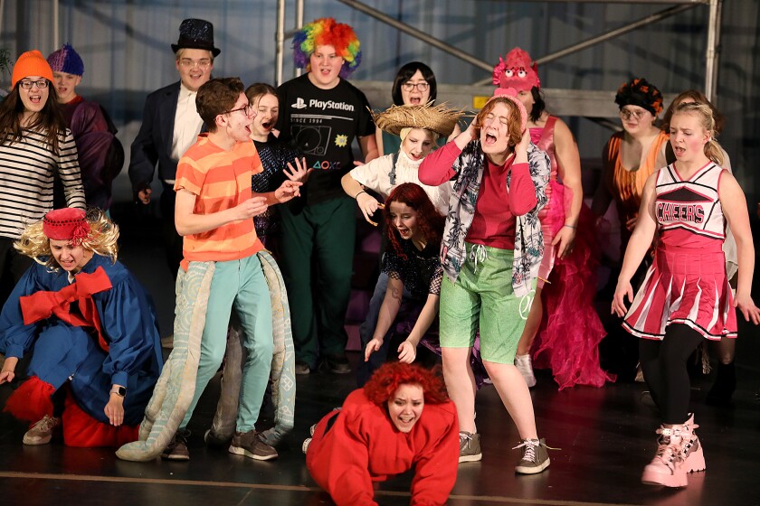 The cast dives around Squidward, played by Julian Robbins, and Patrick, played by Addie Poskozim, during a scene