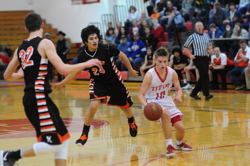 Trinity senior guard Alec Sickler navigates through Killdeer sophomore guard Dayton Danks and senior forward Garrett LeMieux on Friday, Feb. 23 from the Knights of Columbus Activities Center. (Patrick Bernadeau/The Dickinson Press)