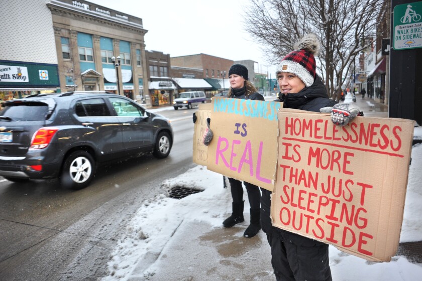 People holding signs along road