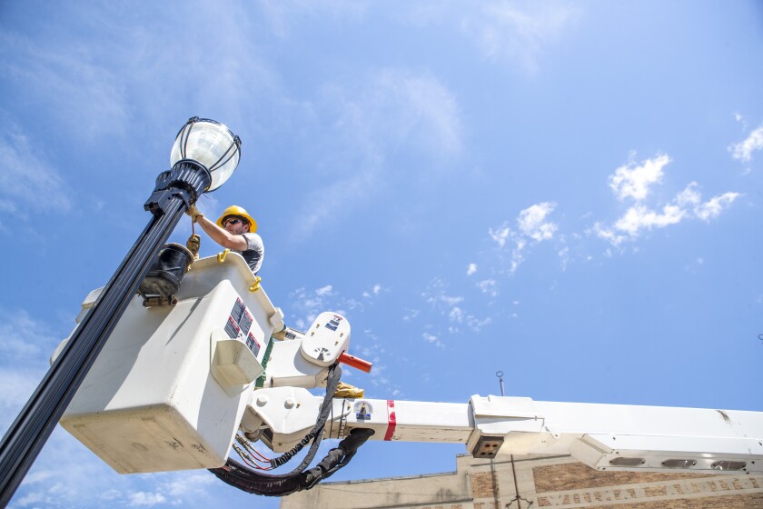 Zach Larson puts the finishing touches on the installation of a new street light along 6th Street SW on Wednesday, June 29, 2022.