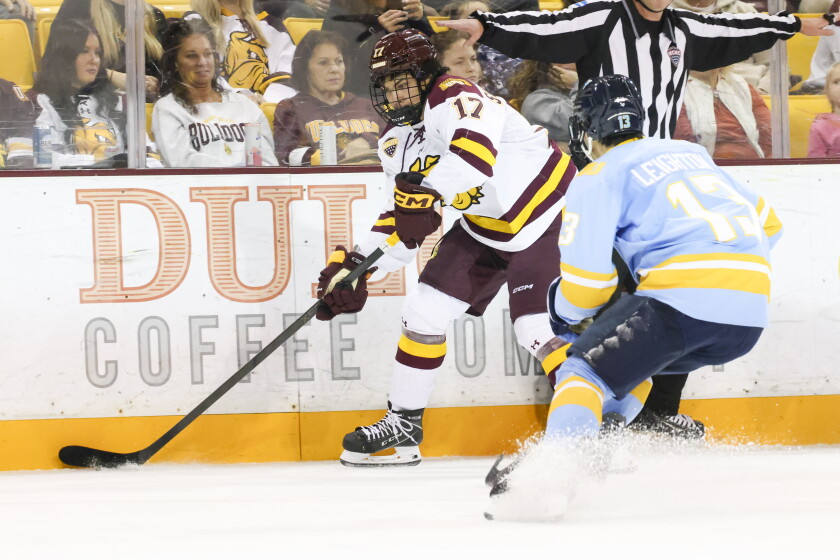 college men play ice hockey indoors