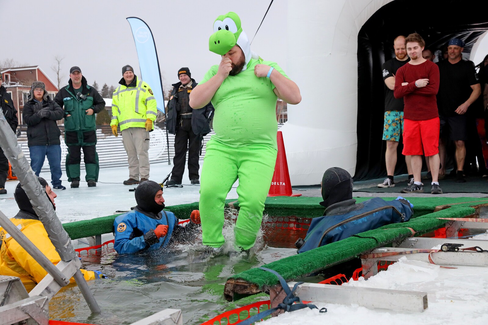 People jump into the water during the Polar Plunge event on Pelican Lake.