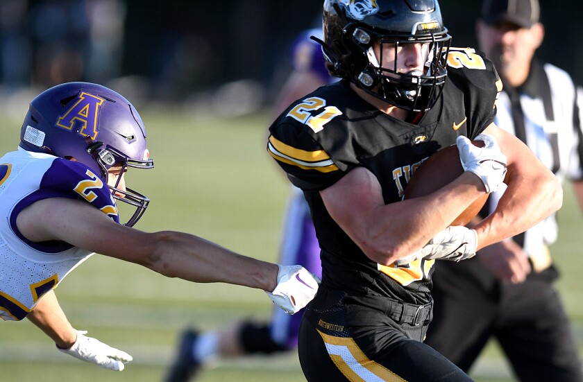 Northwestern’s Kellen Trautt (21) runs through the arms of Ashland’s Marcus Kruzan (22) for a first quarter touchdown