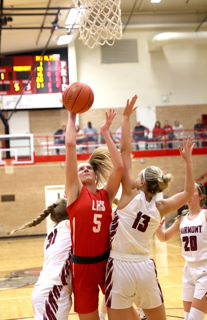 Luverne Elizabeth Wagner (5) finds the seam between Fairmont defenders Cadence Becker (31) and Cassidy Schultz (13) to make a shot at the basket during Section 3AA South Basketball tournament play Friday night in Worthington.