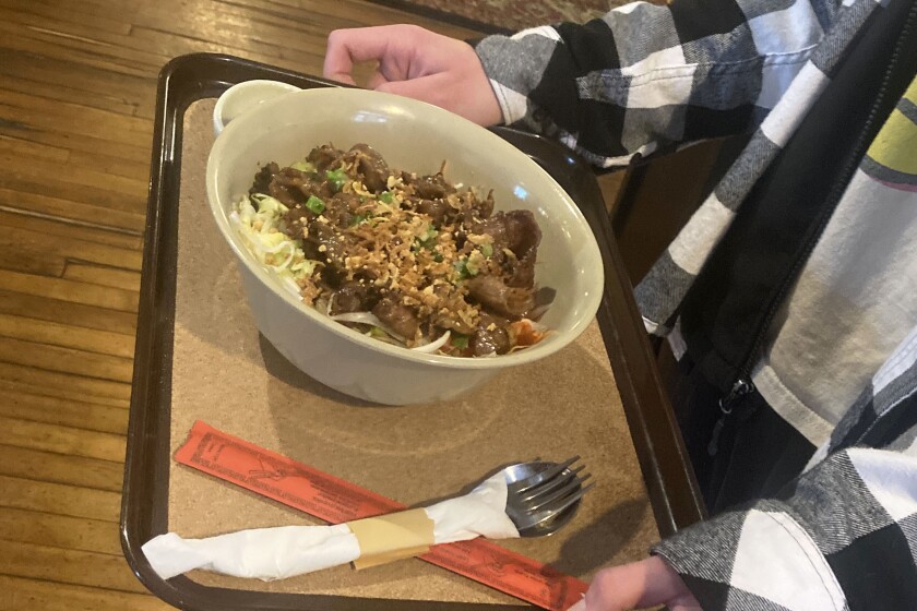 Food on a trey being delivered to a customer at a restaurant.