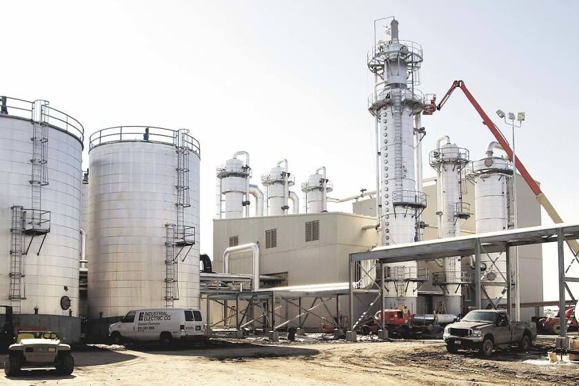 Silos and other components of an ethanol plant, along with several vehicles.