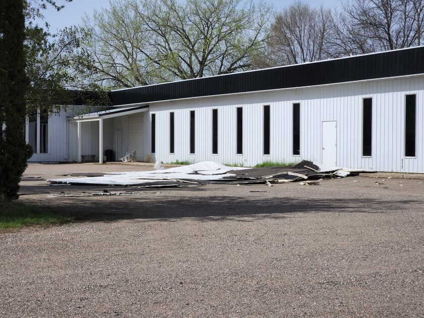 A large portion of a flat roof that blew off a building and fell into the parking lot.