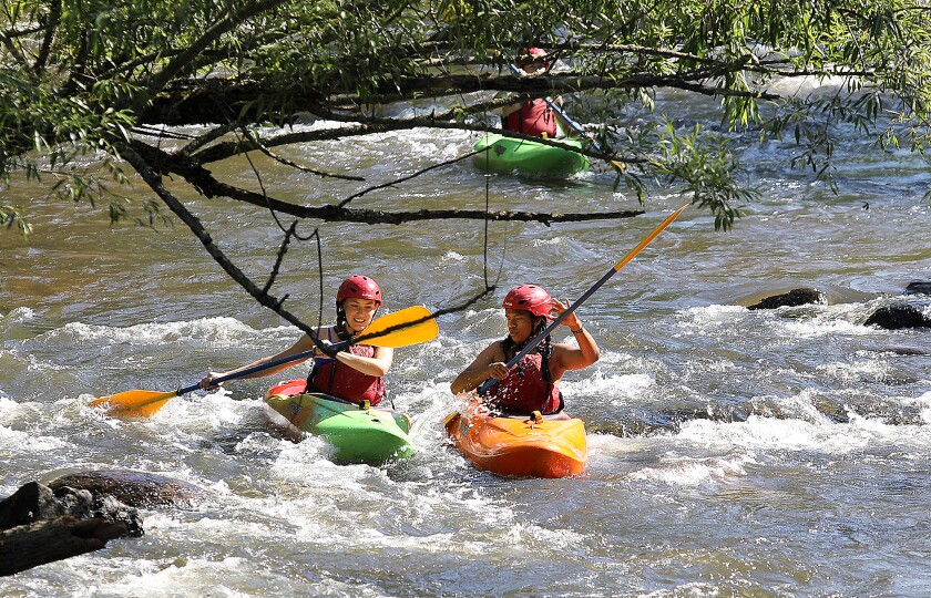 Kayakers navigate some swiftly moving water on the Brule River