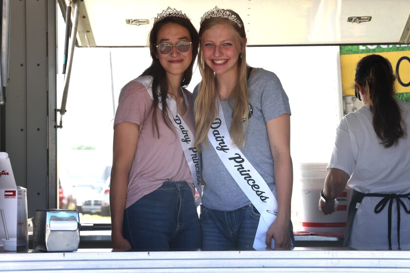 Nobles County Dairy Princesses Nakia Evans, left, and Karen Dykstra, right, serve milkshakes at the Nobles County Fair Thursday, Aug. 4, 2022.