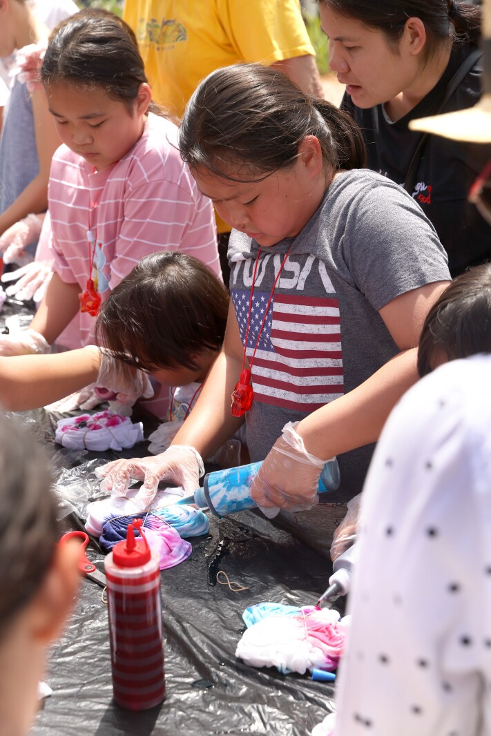 An artist uses tie dye supplies from the ArtMobile during the International Festival on Saturday, July 9, 2022.