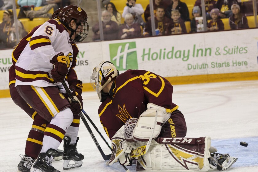 College hockey player play in indoor rink