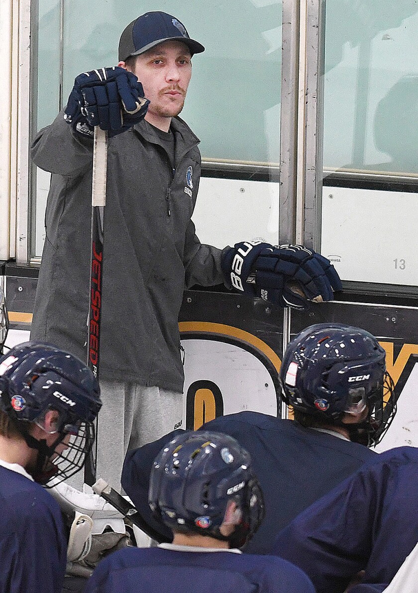Evan Nelson talks to the Spartans during practice at Wessman Arena
