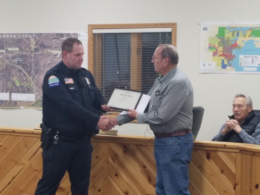 Breezy Point Mayor Tom Lillehei presents Officer Jason Rieber with a Lifesaver Award.