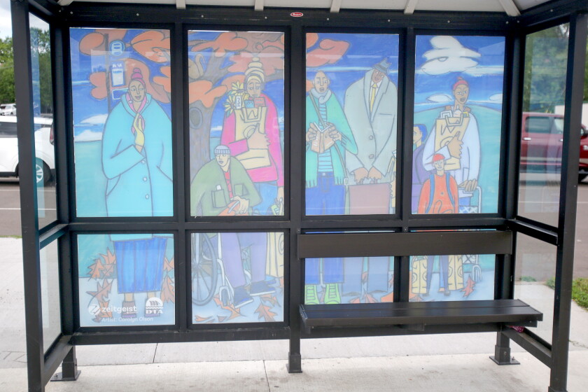 A mural of the windows of a bus shelter showing a fall scene.