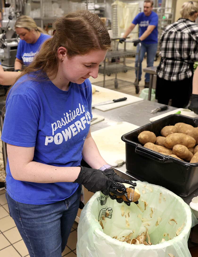Woman peels potatoes.