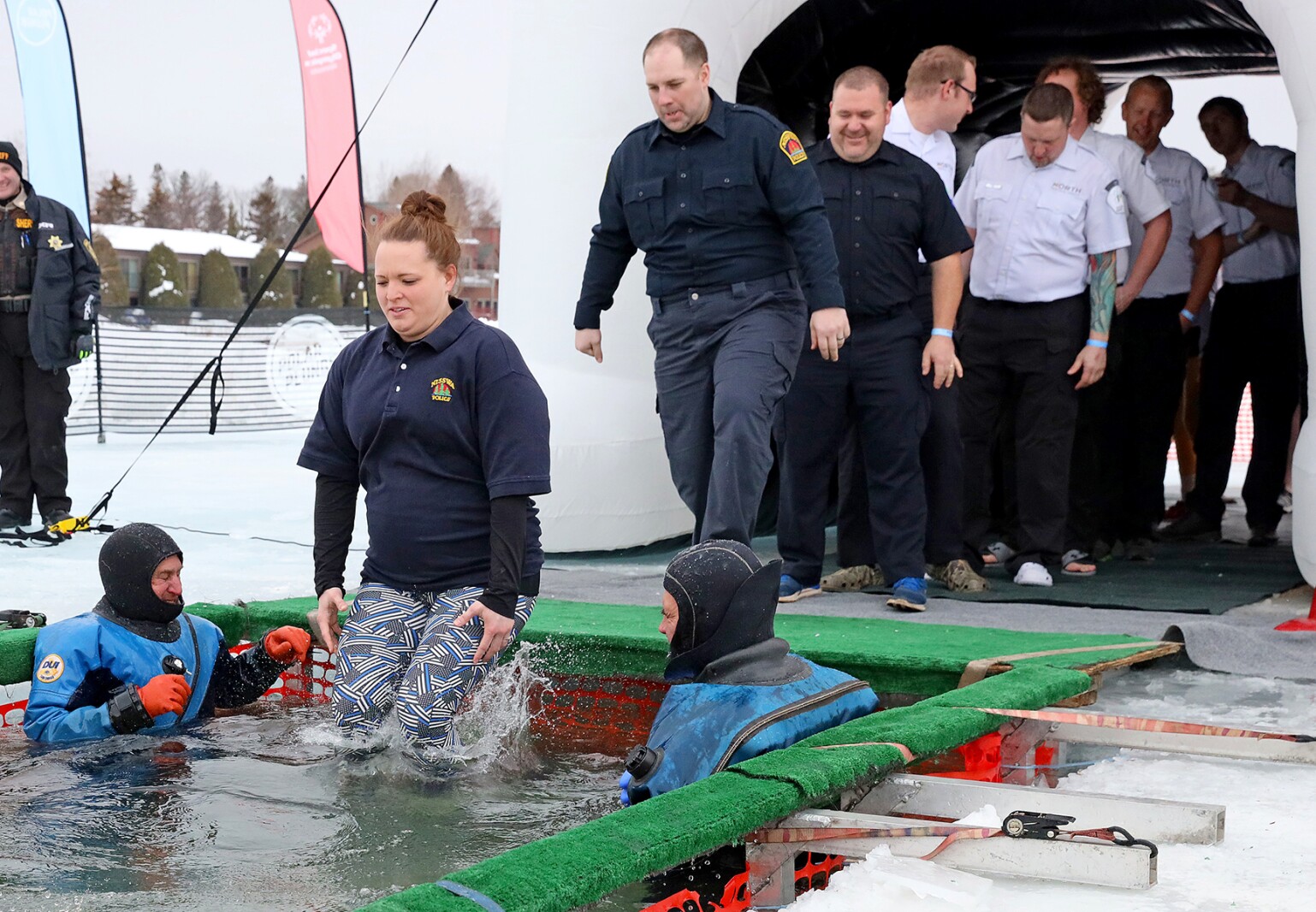 People jump into the water during the Polar Plunge event on Pelican Lake.