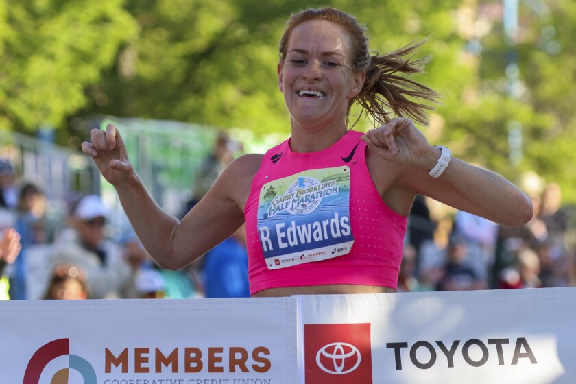 Athletes running and celebrating at the finish line area of Grandma's Marathon
