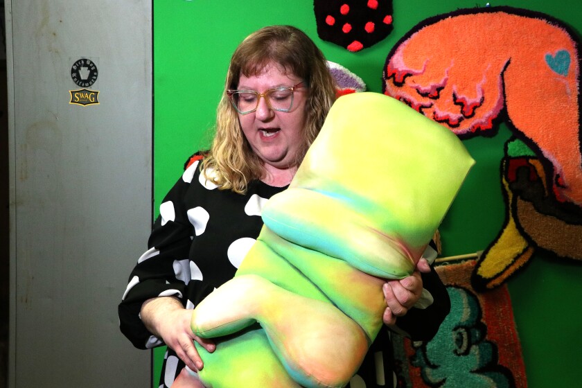 Woman holds piece of artwork.