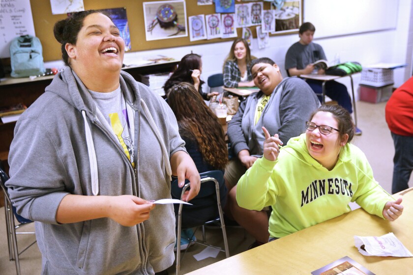 Jolisa Henagin (left) and Brina Rilea crack up when Henagin realizes the Ojibwe history quiz question she's asking the class didn't have the answer written on the card. Students were asked to look up questions and answers for an upcoming quiz bowl competition. Henagin then read them out loud during Ojibwe language class at Cloquet High School on Thursday. Bob King / rking@duluthnews.com