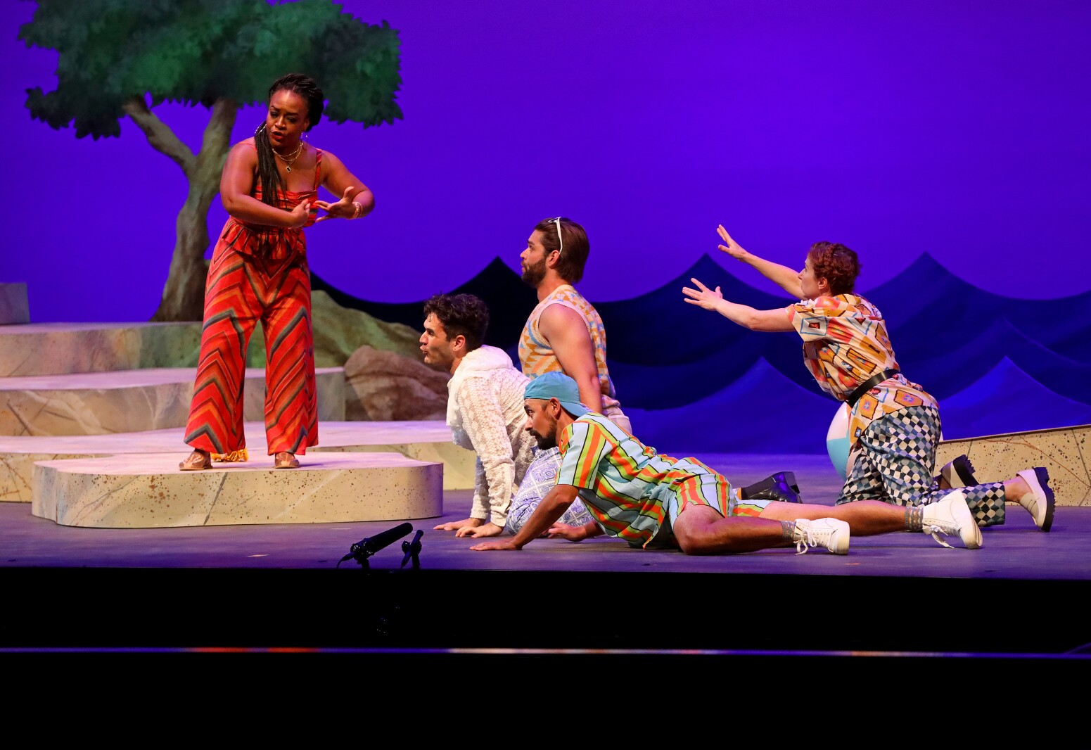 Actors perform on stage.