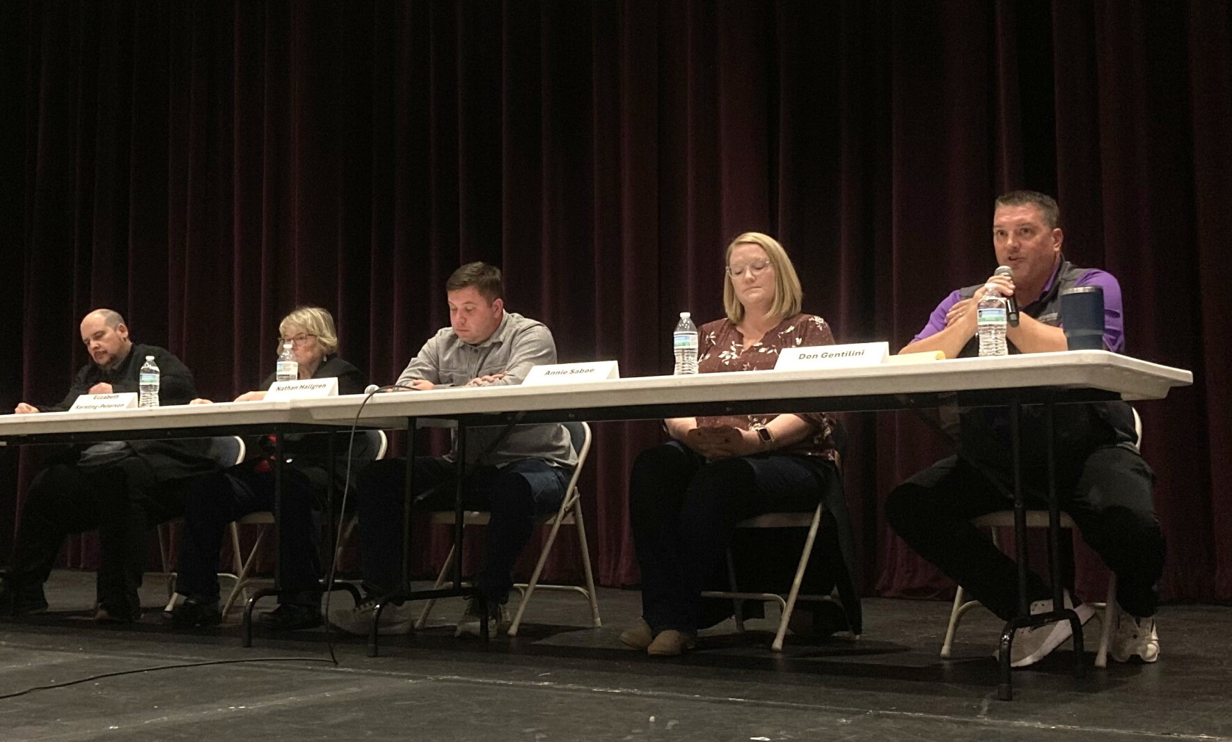 A panel of people sit at a table
