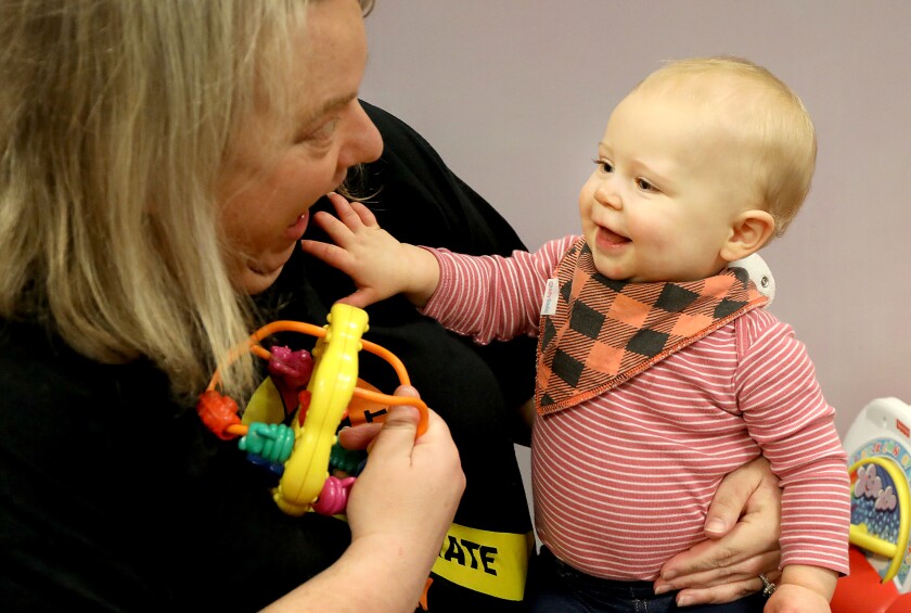 Ten-month-old Brinley Forsberg, right, laughs with Michelle Davis