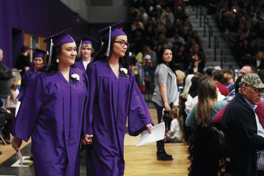 Cousins Raven and Janah Sevilleja holds hands as they walk in the graduation procession to their seats before commencement Friday, May 24. Jamie Lund/Pine Journal