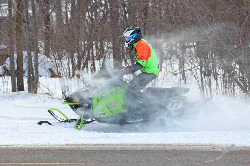 Snowmobilers race.